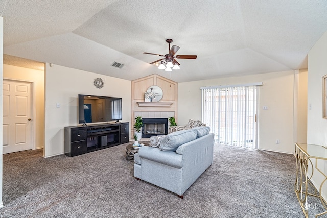 5221 Coral Way, San Angelo, TX 76904 - carpeted living area featuring lofted ceiling, a ceiling fan, a tile fireplace, and a textured ceiling