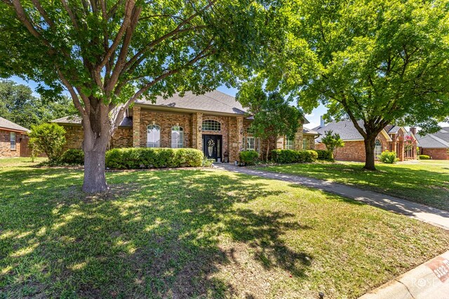 3122 Clearview Dr, San Angelo, TX 76904 - traditional-style house featuring a front lawn, brick siding, and roof with shingles