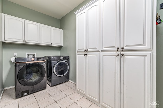3122 Clearview Dr, San Angelo, TX 76904 - laundry area featuring cabinet space, washing machine and clothes dryer, and light tile patterned flooring
