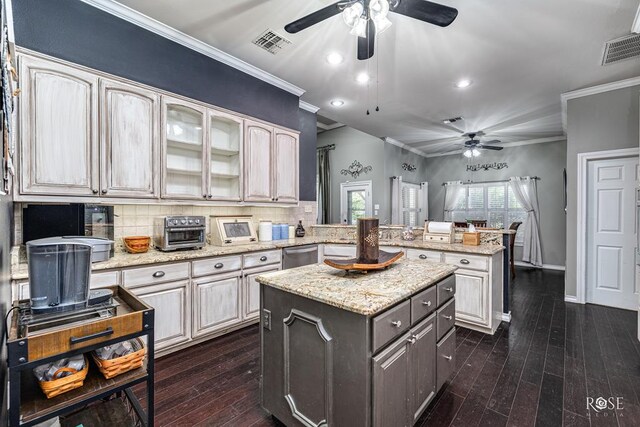 3122 Clearview Dr, San Angelo, TX 76904 - kitchen featuring ceiling fan, crown molding, a kitchen island, a peninsula, and dark wood-style flooring