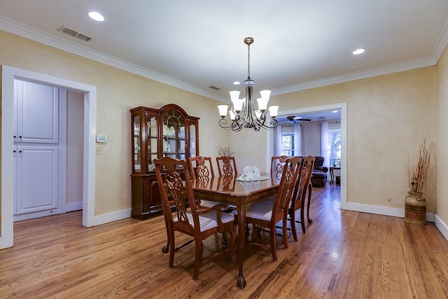 dining area featuring an inviting chandelier, crown molding, and light wood-type flooring