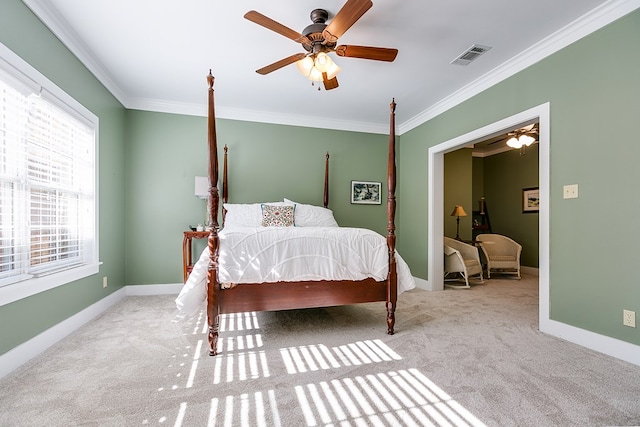 carpeted bedroom with ornamental molding and ceiling fan