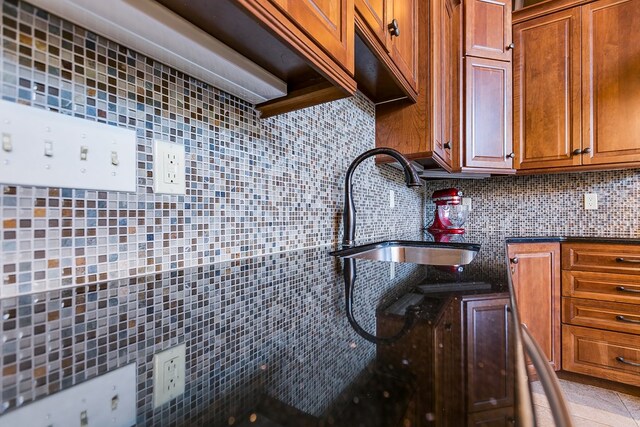 kitchen with tasteful backsplash, sink, and light tile patterned floors