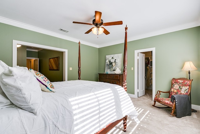 bedroom with ceiling fan, light colored carpet, ornamental molding, and a closet