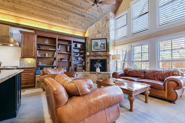 living room featuring ceiling fan, a stone fireplace, wooden ceiling, and high vaulted ceiling