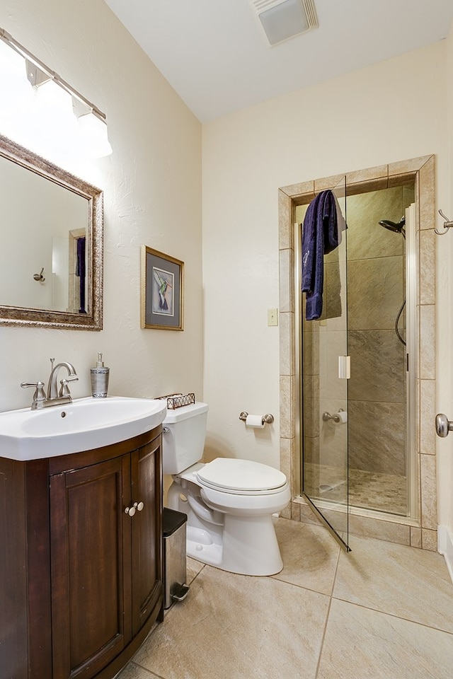 bathroom featuring vanity, a shower with shower door, tile patterned floors, and toilet