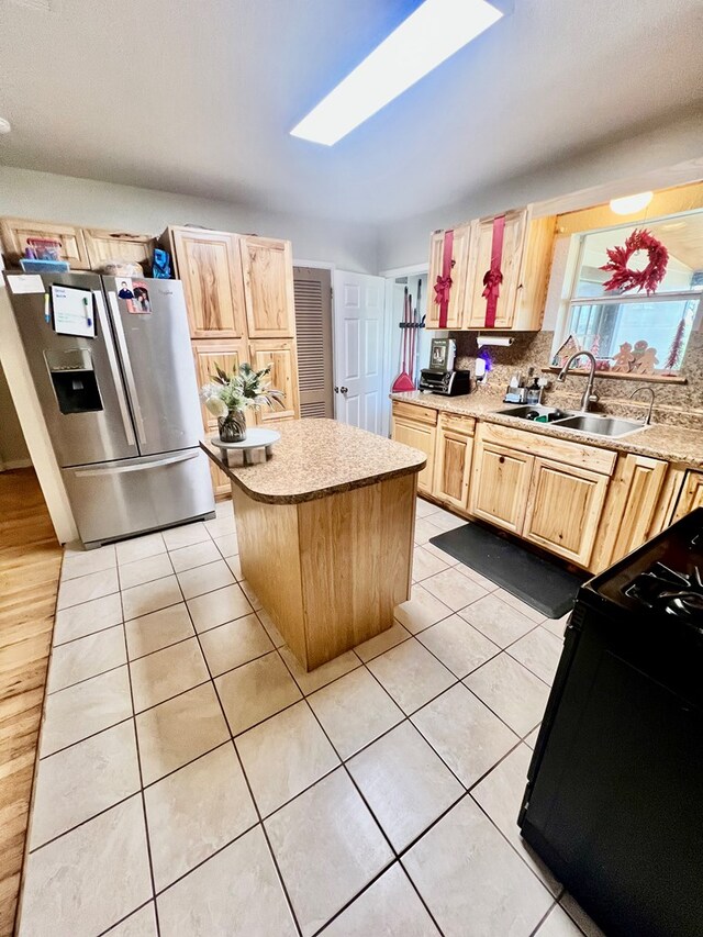 kitchen with a kitchen island, sink, range, stainless steel refrigerator with ice dispenser, and light brown cabinets