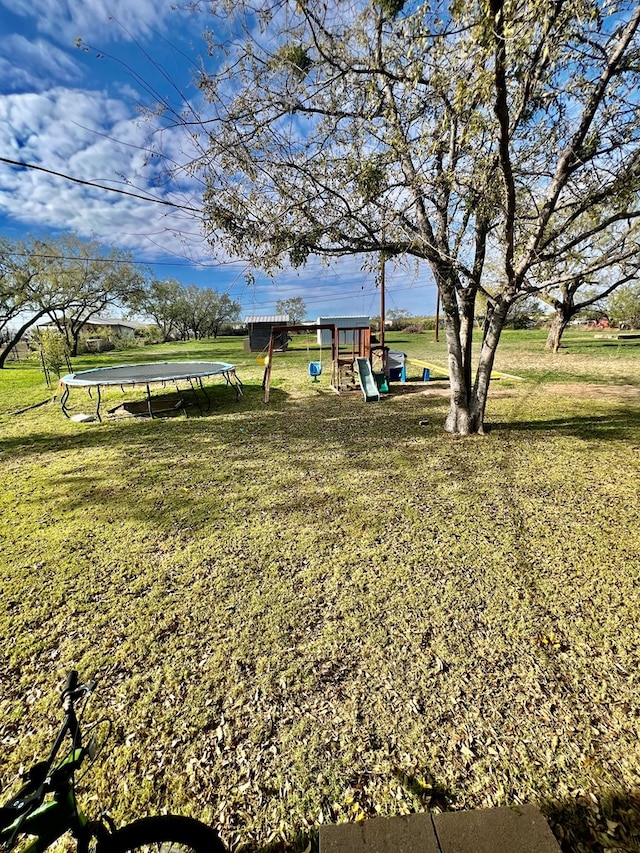 view of yard with a playground and a trampoline