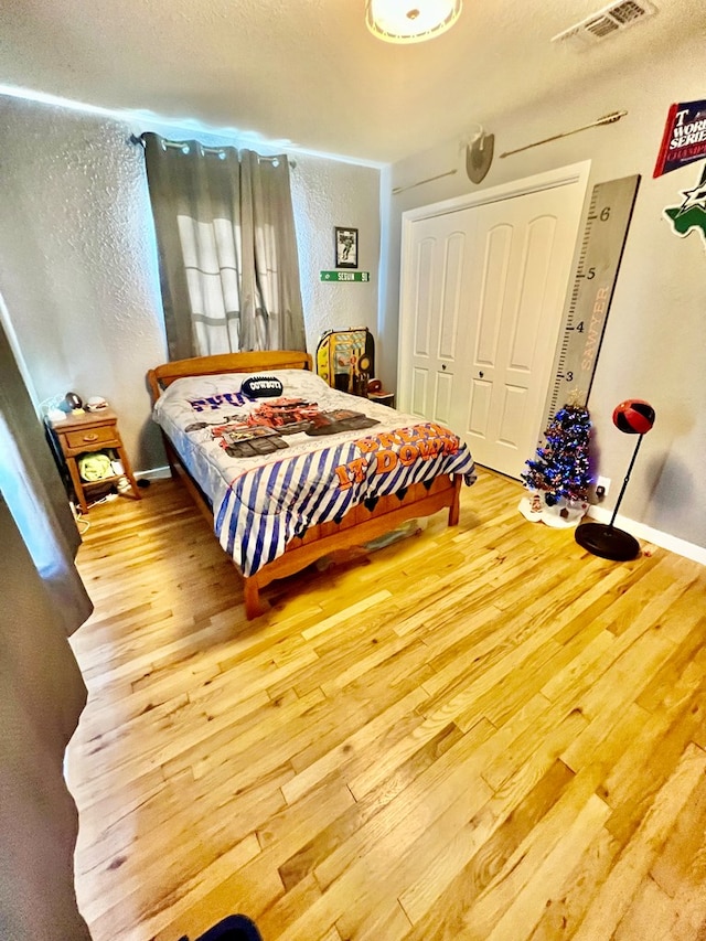 bedroom featuring hardwood / wood-style floors and a closet