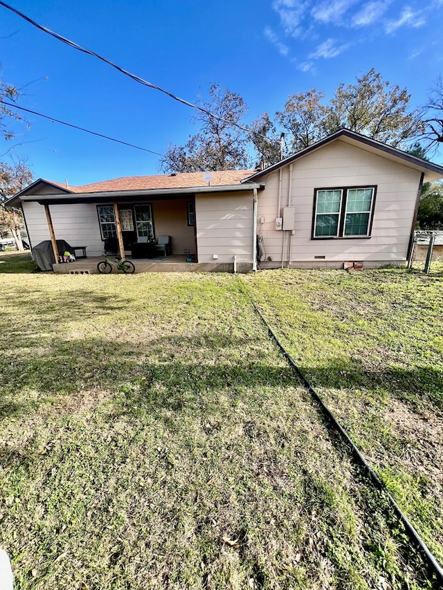 back of property featuring a patio and a lawn