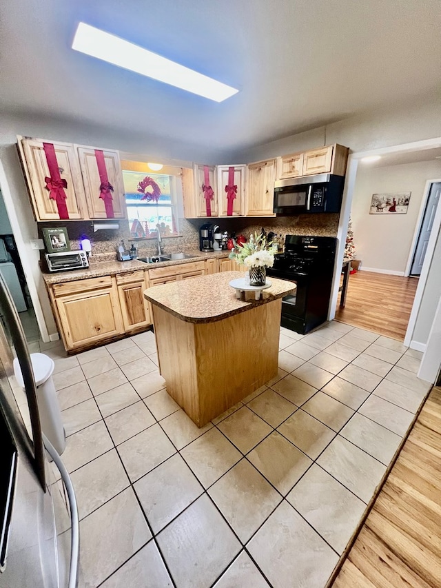 kitchen with a kitchen island, a skylight, sink, decorative backsplash, and black gas range