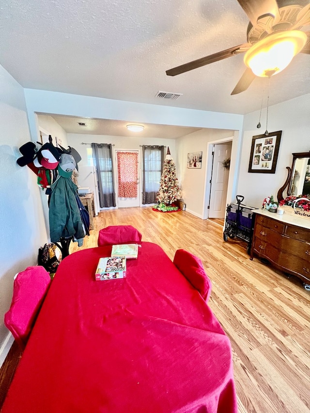 bedroom with ceiling fan, a textured ceiling, and light wood-type flooring