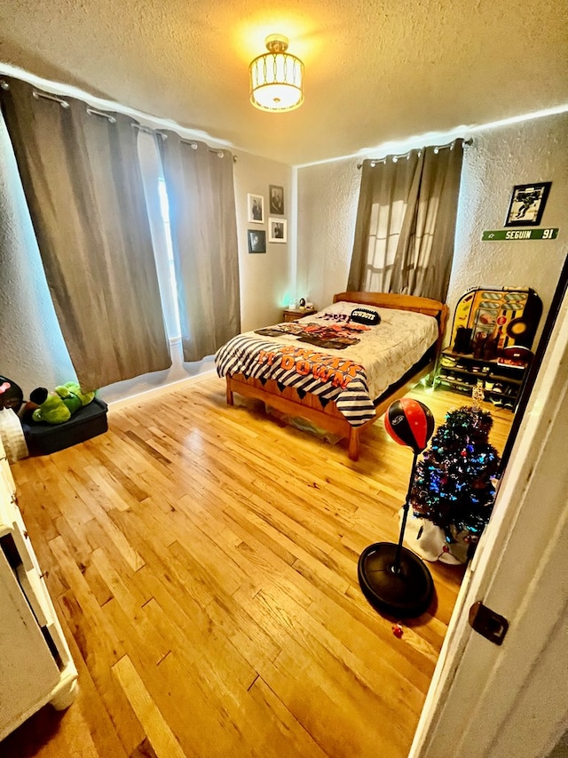 bedroom with hardwood / wood-style flooring and a textured ceiling