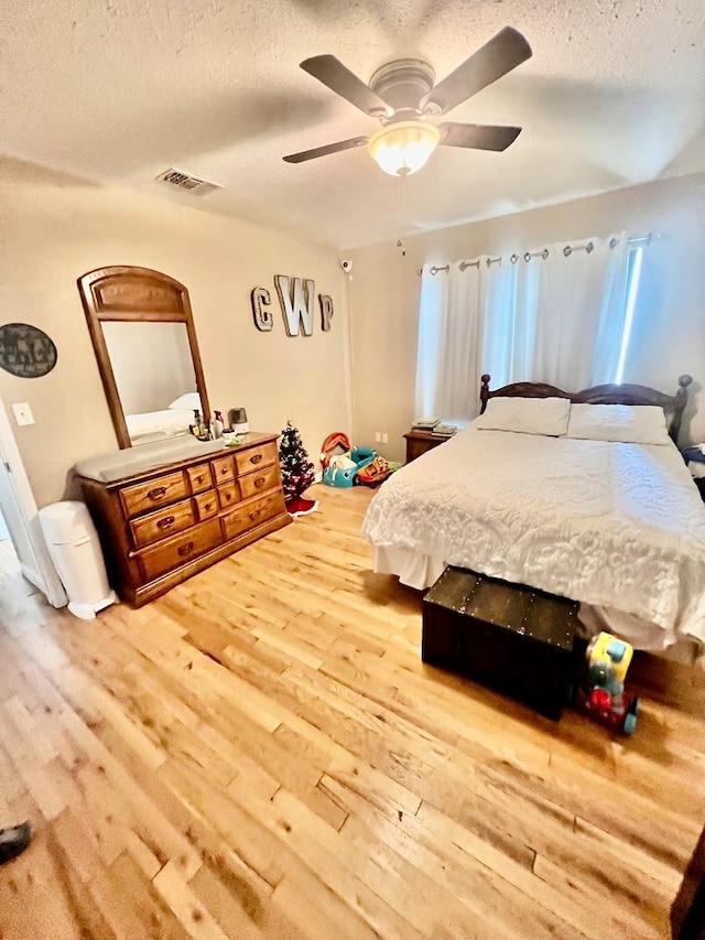 bedroom featuring a textured ceiling, ceiling fan, and hardwood / wood-style flooring