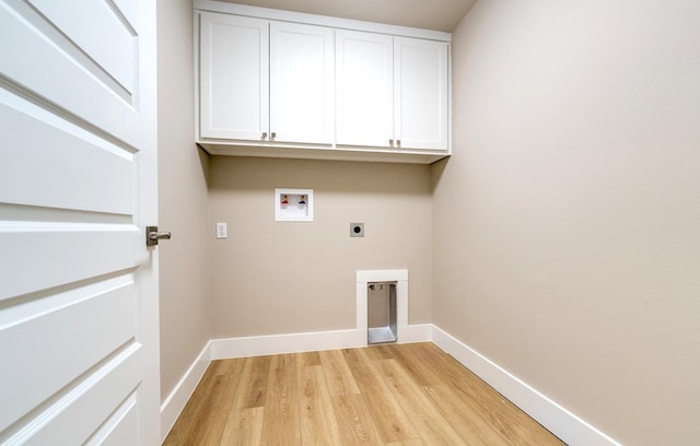 laundry room with electric dryer hookup, washer hookup, light hardwood / wood-style floors, and cabinets