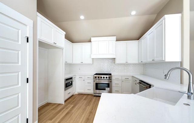 kitchen featuring sink, decorative backsplash, stainless steel appliances, and white cabinets