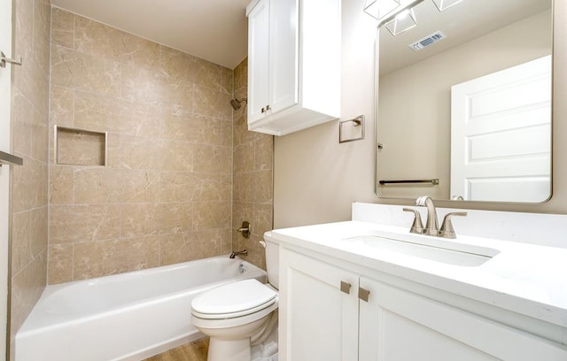 full bathroom featuring vanity, hardwood / wood-style flooring, toilet, and tiled shower / bath