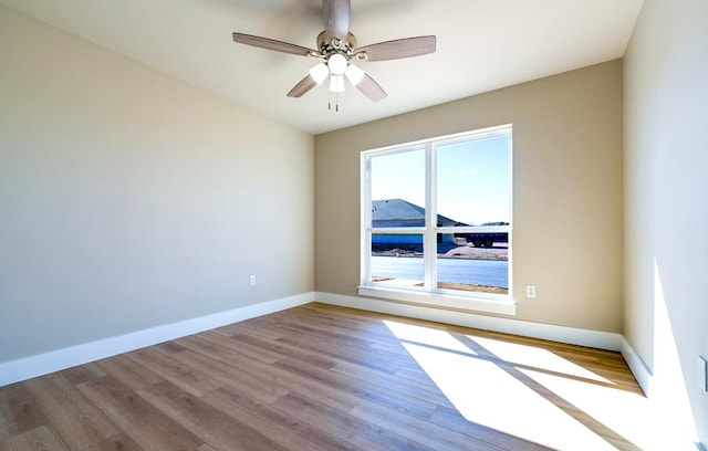 empty room with ceiling fan and light hardwood / wood-style flooring