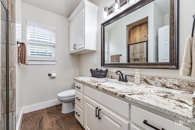 5949 Merrick St, San Angelo, TX 76904 - bathroom featuring vanity, wood finished floors, and tiled shower