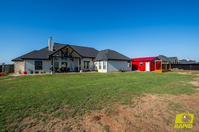 3536 Jaguar Trl, San Angelo, TX 76901 - rear view of property featuring a storage unit, an outdoor structure, a chimney, and roof with shingles