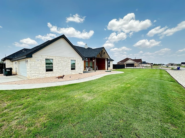 back of house featuring a yard, a chimney, fence, a garage, and driveway