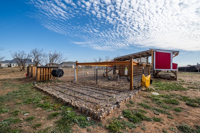 view of yard with an outdoor structure, fence, and exterior structure