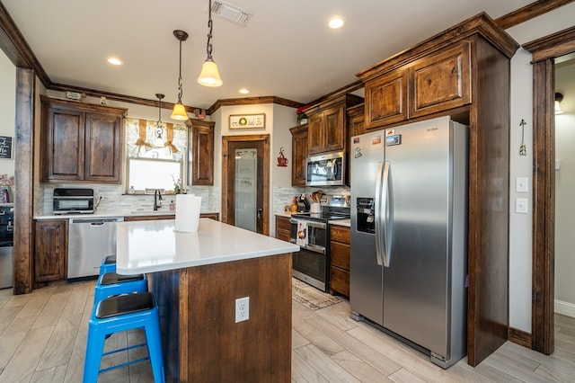 kitchen featuring crown molding, visible vents, stainless steel appliances, and backsplash