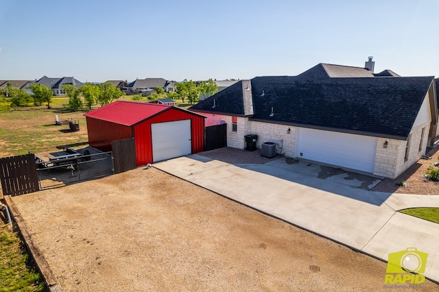 3536 Jaguar Trl, San Angelo, TX 76901 - view of home's exterior with fence, a shingled roof, a chimney, an outbuilding, and a garage