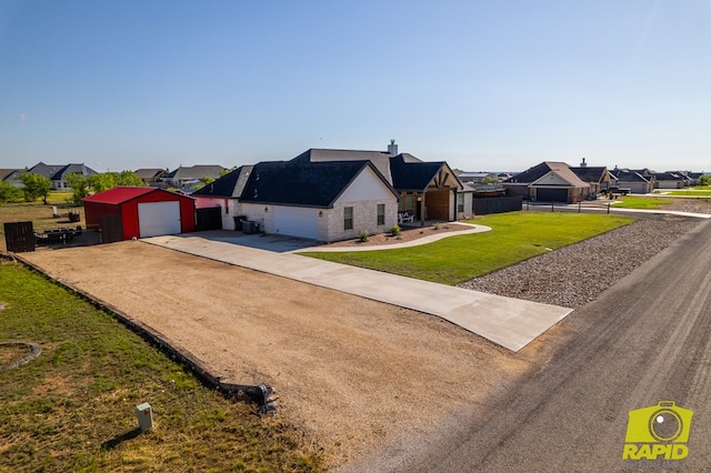 3536 Jaguar Trl, San Angelo, TX 76901 - view of front of house with driveway, a residential view, an outbuilding, and stone siding