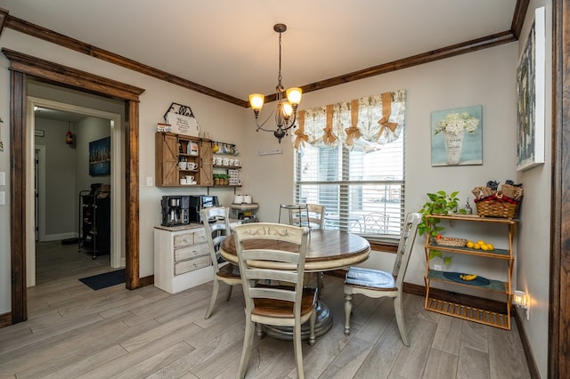 dining space with wood finish floors, a notable chandelier, crown molding, and baseboards