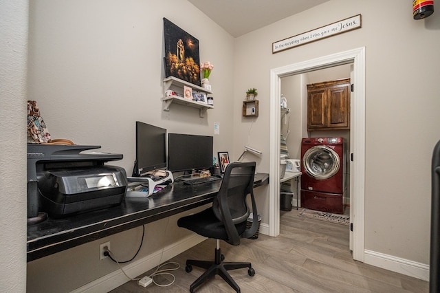 office featuring light wood-style floors, baseboards, and washer / dryer