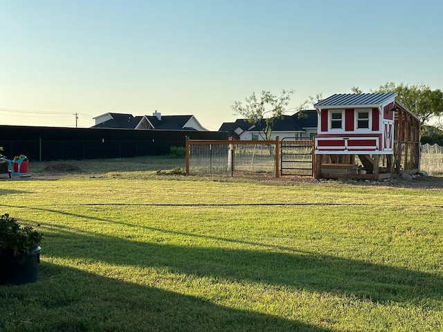 view of yard with exterior structure, fence, and an outbuilding