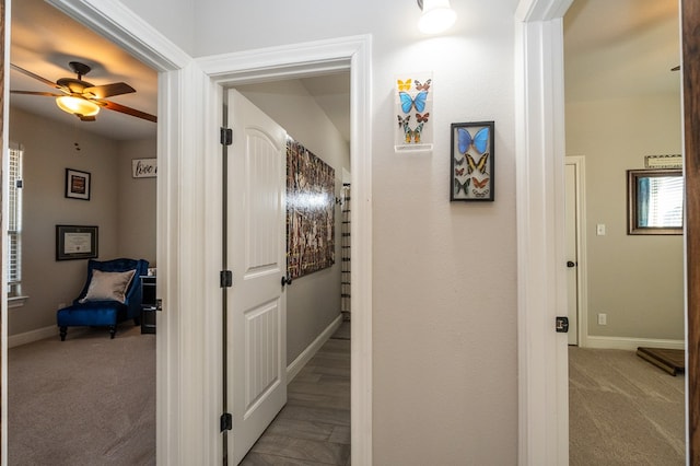 hallway featuring carpet floors and baseboards