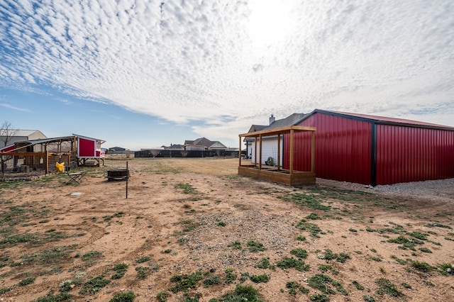 view of yard with exterior structure, a pole building, and an outdoor structure