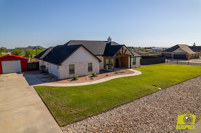 3536 Jaguar Trl, San Angelo, TX 76901 - view of front of house with stone siding, concrete driveway, a chimney, an outbuilding, and a shingled roof