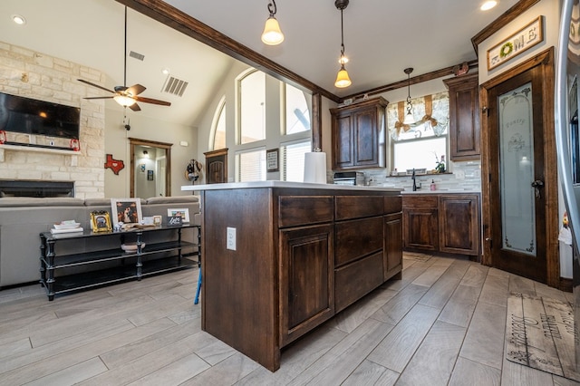 kitchen featuring open floor plan, dark brown cabinets, vaulted ceiling, and visible vents