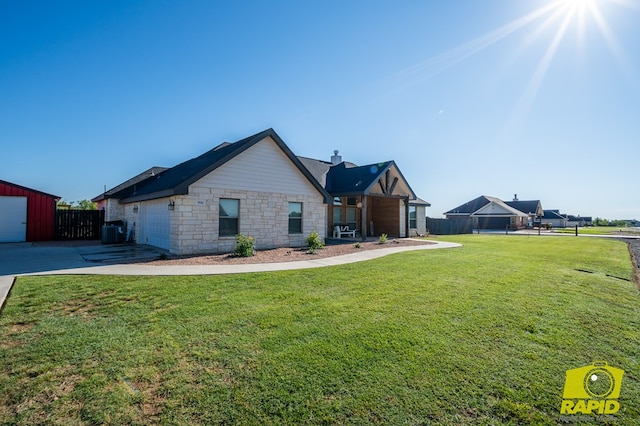 3536 Jaguar Trl, San Angelo, TX 76901 - view of front of home with stone siding, a chimney, central air condition unit, concrete driveway, and a garage