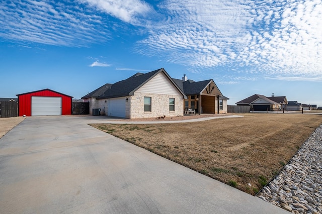 ranch-style house with central air condition unit, concrete driveway, fence, stone siding, and a front lawn