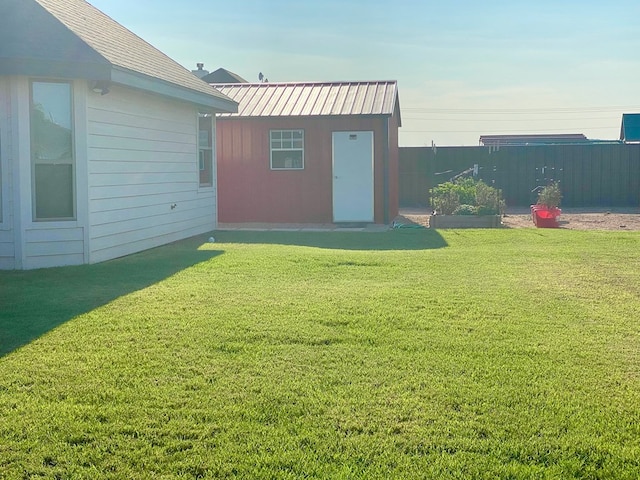 view of yard featuring fence and an outbuilding