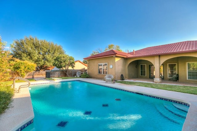 view of swimming pool with a diving board and a patio