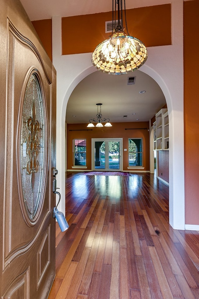 foyer entrance with an inviting chandelier and wood-type flooring