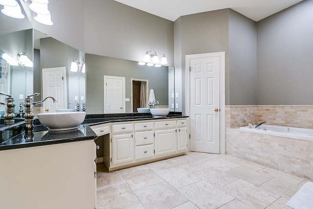 bathroom with vanity and tiled bath