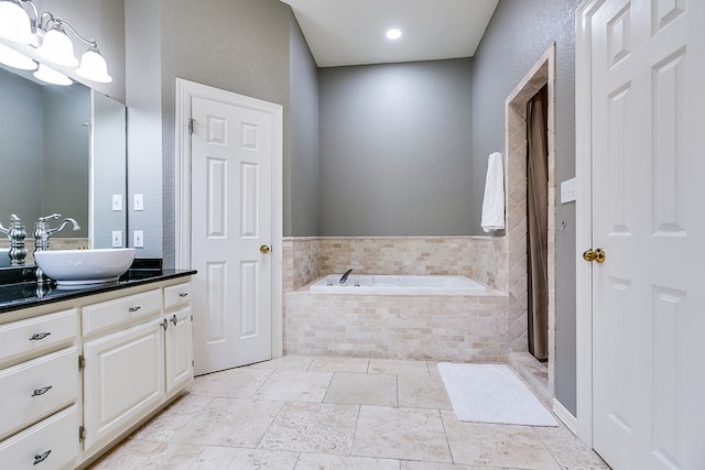 bathroom featuring vanity and tiled tub