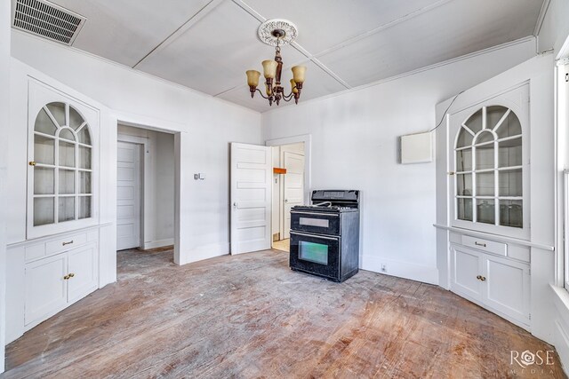 804 S Concho Ave, Sonora, TX 76950 - kitchen with black range oven, a chandelier, light wood-style floors, baseboards, and white cabinetry