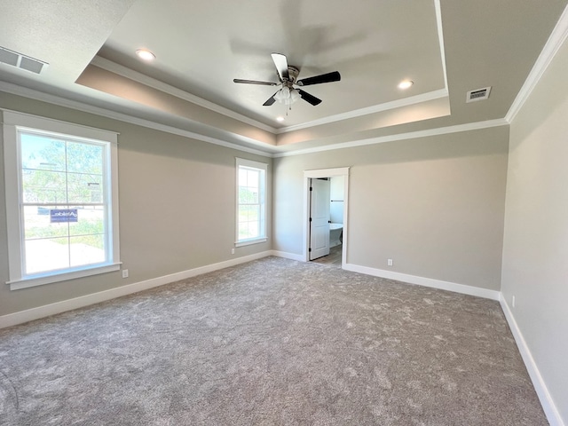 unfurnished bedroom featuring ornamental molding, a raised ceiling, visible vents, and baseboards