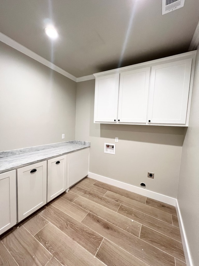 washroom featuring washer hookup, wood finish floors, cabinet space, ornamental molding, and baseboards