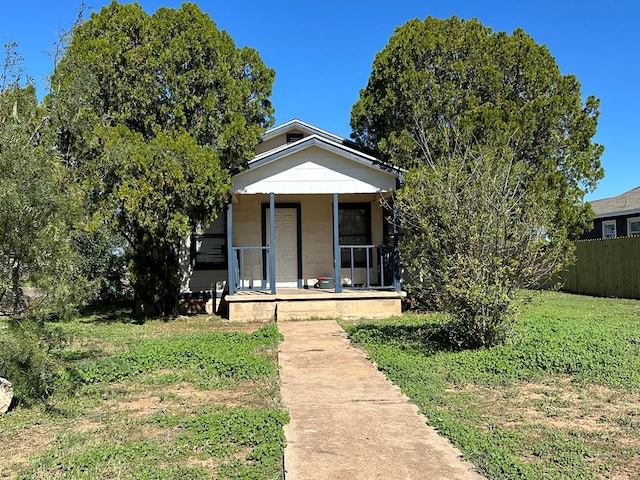 bungalow-style house featuring covered porch and a front yard