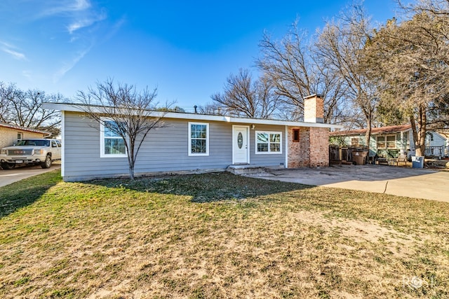 single story home featuring a chimney and a front lawn