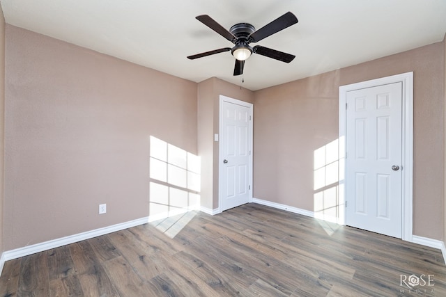 unfurnished room with ceiling fan, wood finished floors, and baseboards