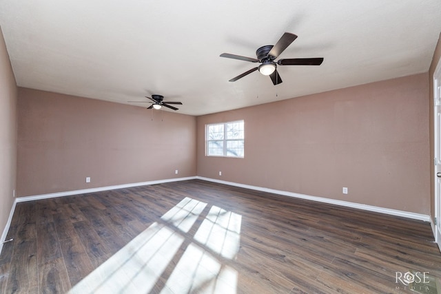 spare room with ceiling fan, baseboards, and dark wood finished floors